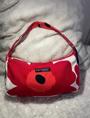 Marimekko Vintage Unikko shoulder bag - Beautiful Marimekko canvas bag with red floral patterns. In very good condition, but with some wear in places. There is some wear/fading in the fabric in places, and some fading on the zipper fastener. The inside is clean.  Lovely for summer ☀️🌺