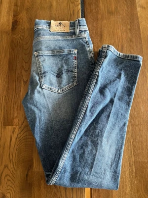 Replay Jeans - Säljer ett par klassiska blå jeans från Replay med snygga detaljer och slim fit. Perfekt för dig som gillar en slim fit  och trendig stil