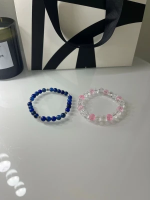 Två pärlarmband i blått och rosa - Superfina pärlarmband köpta utomlands. Båda för 20kr, går även att bara köpa ett för lägre💕