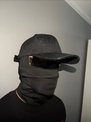 Svart Fendi keps - Snygg svart keps med böjd skärm och diskret ton-i-ton mönster på ovansidan. Klassisk sexpanel-design och justerbar rem bak. Passar perfekt till streetwear och ger en clean look.