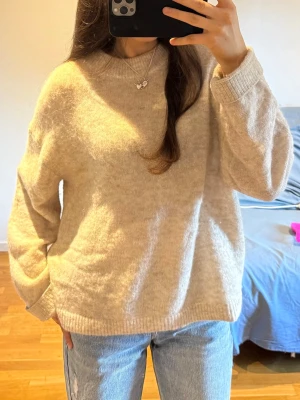 Beige stickad tröja HM - Säljer denna stickade tröja från HM. Storlek S, oversized i modellen så passar M också. Använd men i fint skick. Har några defekter i form av ett litet hål vid ena armen och lite smuts i ullen som man kan se på bilderna. Är lite nopprig. Samt har små fläckar av smink på lappen och vid kragen. 230 kr + frakt! Vid fler frågor, etc skriv privat 🙌🏼🩷☀️🏄🏽‍♀️🌄