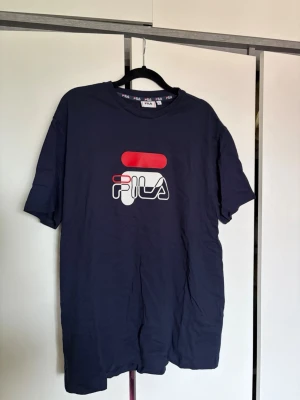 Mörkblå FILA t-shirt  - Snygg mörkblå t-shirt från FILA med stor logga i vitt och rött på bröstet. 