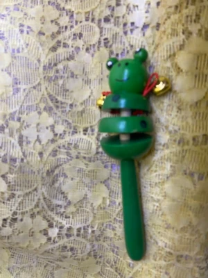 Vintage Trä skallra Leksaker  - Söt skallra i trä formad som en grön groda med ett leende ansikte och små bjällror på sidorna. Handtaget är avlångt och hela skallran är målad i olika nyanser av grönt. Perfekt som leksak eller dekoration. 45kr/st . Finns olika färger kvar. 3år + 
