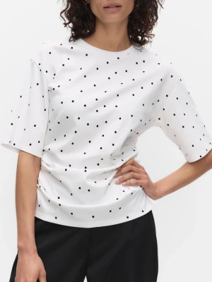 Vit prickig t-shirt med snörning - Säljer en vit t-shirt med svarta prickar och cool snörningsdetalj i sidan. T-shirten har korta ärmar och en avslappnad passform. Perfekt för dig som gillar en lekfull men stilren look. Nypris 399