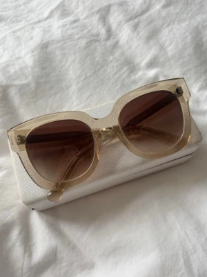 CHIMI solglasögon - Snygga solglasögon med transparent beige båge och bruna tonade glas från CHIMI. Modell 08 i färgen Ecru. Säljer pga använder inte längre. Ena bågen är lite lös men går att skruva åt, inget som påverkar användningen! Orginalpris 1400kr.