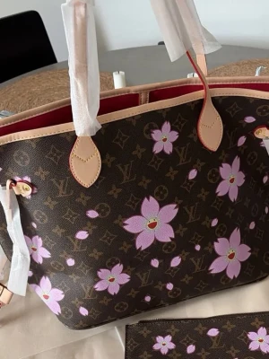 Väska  - Helt ny Neverfull väska med murakami blommor. Väskan är i äkta läder och har röd insida