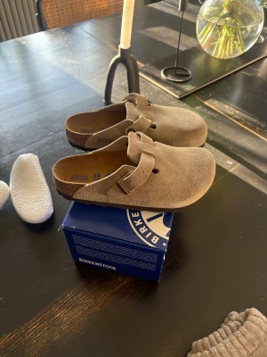 Beige Birkenstock Boston tofflor - Säljer ett par snygga beige Birkenstock Boston. Tofflorna är helt nya med lappar och kartong kvar. Aldrig använda. 
