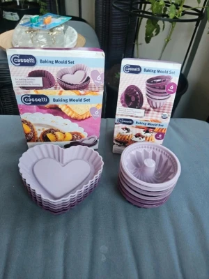 Lila bakformar i silikon från Cassetti - Två set med lila bakformar i silikon från Cassetti. Ett set med hjärtformade formar och ett set med små sockerkaksformar, båda med sex delar. Perfekta för muffins, kakor eller desserter. Tål både ugn och frys.