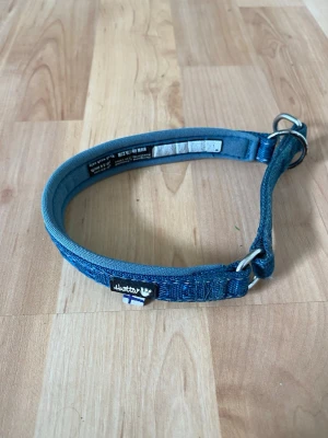 Blått hundhalsband från Hurtta 25-35cm - Säljer ett blått hundhalsband halvstyp från Hurtta 25-35 cm. Halsbandet är vadderat för extra komfort och har metallringar för koppel. Passar mindre hund.
