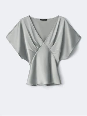 Silkes omlottblus med knytning  - Snygg silvrig omlottblus i satinliknande material med v-ringning och korta, vida ärmar. Blusen har knytband i ryggen för en justerbar passform och ett elegant fall. Perfekt för dig som vill ha en stilren och trendig look.