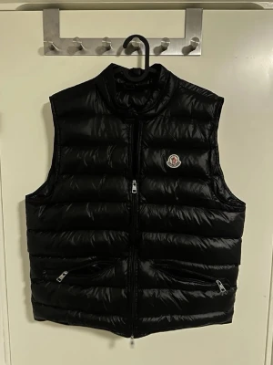 Moncler Gui väst - Riktigt schysst svart Gui väst från Moncler. Säljes då den var  för kort för mig, storlek 3, rätt så bra skick enligt mig, hör av er vid frågor/funderingar och prisförslag! ✌️