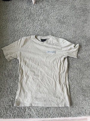 Ljus grön t-shirt från Peak Performance - Säljer en ljus grön (khaki) t-shirt från Peak Performance med enkel design och liten logga på bröstet. T-shirten har rund hals och korta ärmar, perfekt för en clean och avslappnad stil. Tillverkad i mjuk bomull för skön känsla hela dagen.