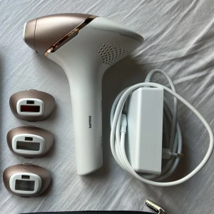 Philips Lumea IPL hårborttagningsapparat - Säljer en helt ny och oanvänd Philips Lumea IPL 9900 hårborttagningsapparat i vitt och roséguld. Medföljer tre olika munstycken, laddare och en förvaringsväska. Perfekt för smidig hårborttagning hemma och kan kopplas till Philips Lumea appen för extra funktioner. Orginalpris 7999