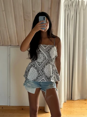 Mönstrad peplum-topp / linne - Söt topp med snörning/detaljer och paisley-/bandanamönster. Sitter superfint på!