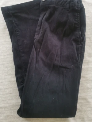 Mörkblå chinos från H&M - Säljer ett par mörkblå chinos från H&M i storlek 152. Klassisk rak passform med knapp och dragkedja framtill samt fickor både fram och bak. Perfekta till en avslappnad och stilren look.