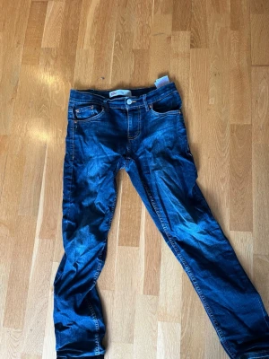 Levi's 512 Slim Taper jeans blå - Säljer ett par Levi's 512 Slim Taper jeans i mörkblå denim. Modellen har smal passform med avsmalnande ben, klassiska fem fickor och snygga kontrastsömmar. Perfekta för dig som gillar en modern och stilren look. Småslitna där nere men annars bra, strlk 158-164