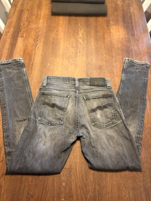 Grå slim fit jeans från Nudie Jeans - Snygga grå slim fit jeans från Nudie,               storlek 29/32. Hör av er om ni har några frågor eller om ni vill ha fler bilder!