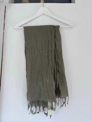Halsduk Beck Söndergaard - En tunnare, lång halsduk från Bäck söndergaard. Helt oanvänd och lappen sitter kvar! Färgen heter fossil Brown. Skulle säga att den är lite grå/beige med inslag av khaki. Perfekt till hösten & pris kan ofta diskuteras!🥰