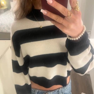 Randig croppad tröja från H&M Divided - Säljer en croppad stickad tröja från H&M Divided i svart och vitt med breda ränder. 