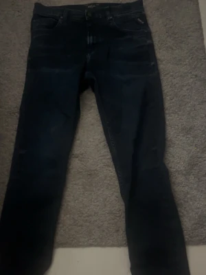  Replay jeans - Säljer ett par mörkblå jeans med slim/ rak passform. Klassisk femficksmodell och diskreta sömmar. Perfekta till en avslappnad stil och passar till det mesta. Materialet är bomull vilket gör dem bekväma att bära hela dagen.