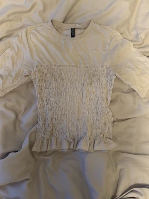 Vit topp med smock och volang - Söt topp från hm möjligen lite urtvättad därav priset💗