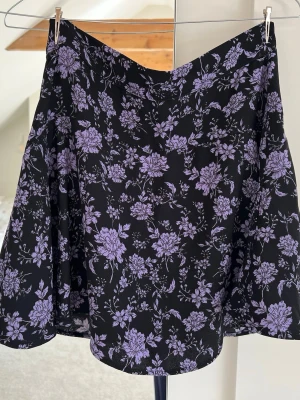Svart blommig kjol  - En svart kjol från Zara med lila blommönster i storlek S :)
