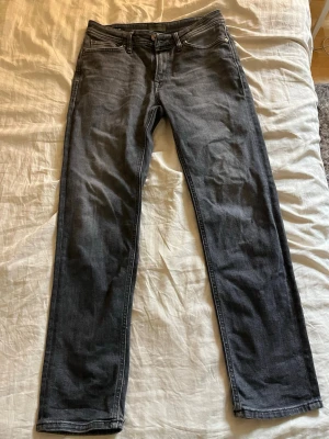 Svarta slim fit jeans, storlek 29/32 - Snygga svarta slim fit jeans med klassisk femficksdesign och diskreta sömmar. Jeansen har en något tvättad look och passar perfekt till en avslappnad stil. Tillverkade i stretchigt denim för extra komfort.