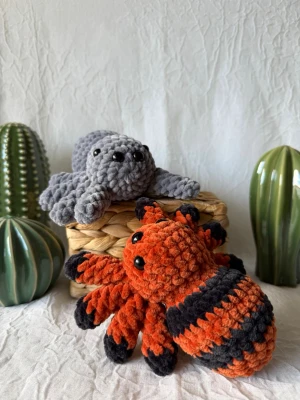 Virkad spindel orange - Den här handvirkade spindeln har en mjuk orange/svart kropp, åtta ben och ett charmigt ansikte – lagom kuslig och perfekt till hösten. Finns även i grå.   • Handvirkad • Material: 100 % polyester • Fyllning: polyesterstoppning, återbrukade garnrester kan förekomma • Säkerhetsögon av plast – rekommenderas ej för barn under 3 år • Mått: ca 16,5 × 15 cm  Eftersom varje spindel är handgjord kan små variationer förekomma.