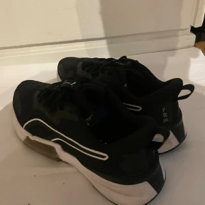 Svarta sneakers med vit sula - Snygga svarta sneakers med vit sula och vita detaljer på sidan. Skorna har en sportig design med lågt skaft och snörning. Materialet ser ut att vara en mix av textil och syntet. Perfekta för dig som gillar en clean och stilren look. Köpte för 1900 499 är bra pris begnagnat