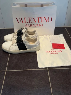 Valentino Garavani vita sneakers - Hej! Säljer nu mina valentino open garvani skor. Storlek 41 och håller en väldigt bra kvalitet. Äktahets bevis finns genom kvittot. Som ni ser på bilderna så är sulan sprucken men annars inga problem. Har säker glömt skriva något så bara att fråga😁Priset är inte huggit i sten så kom gärna med bud🤠