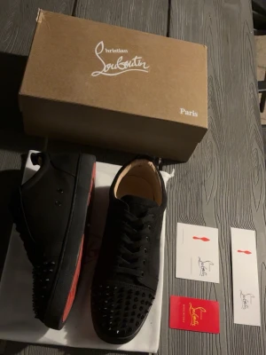 Louboutins - Säljer ett par svarta Louboutins med nitar, storlek 45. Riktigt snygga och i mycket bra skick. Skorna kommer med skokartong & dustbag. Säljer skorna då jag föredrar mina blåa och därför inte använder dessa. Är du intresserad? Skicka gärna ett bud!