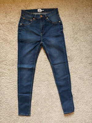 Mörkblå jeans med hög midja - Helt nya och oanvända! Snygga mörkblå skinny jeans från Lager 157 med klassisk femficksdesign och kopparfärgade nitar. Jeansen har hög midja och smal passform hela vägen ner. Perfekta för dig som gillar en stilren och enkel look. Superfina och trendiga i höst. 
