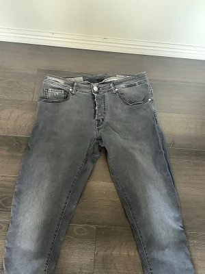 Slim fit jeans från Tramarossa - Snygga grå jeans från Tramarossa med klassisk femficksmodell och knappgylf. Jeansen har en tvättad look och detaljerade sömmar. Perfekta för dig som vill ha ett par stilrena och bekväma jeans med modern passform. 