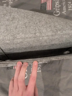 Grå filtad förvaringsficka  - Praktisk förvaringsficka i grå filt, perfekt att hänga på soffkanten eller sängkanten för att förvara fjärrkontroller, tidningar eller surfplatta. Enkel och stilren design som smälter in i de flesta hem. Fickan är mjuk men stadig och har en öppning upptill.