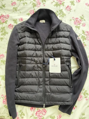  Moncler cardigan - Svart Moncler cardigan utan luva. Storlek M. Helt ny. Tveka ej att höra av vid frågor eller fler bilder. Kan säljas billigare vid snabb affär.