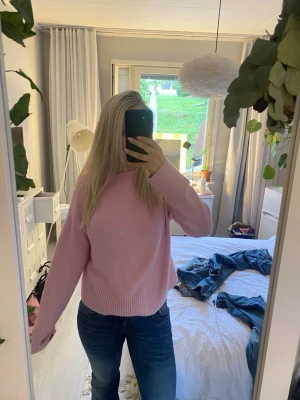 Ljusrosa stickad tröja - Söt ljusrosa stickad tröja med rund halsringning och ribbade muddar vid ärmslut och nederkant. Tröjan har en avslappnad passform och är perfekt för dig som gillar en enkel men stilren look. Passar till både jeans och kjol.