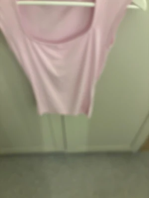 Ljusrosa ärmlös topp - Säljer en ljusrosa, tight och ärmlös topp med rund halsringning. Toppen har en enkel och clean design, perfekt att styla med jeans eller kjol. Materialet känns mjukt och stretchigt, vilket gör den bekväm att bära.