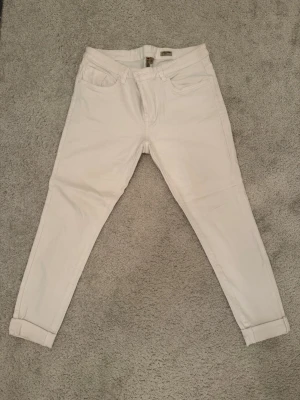Vita super skinny jeans Lee Cooper - Säljer ett par vita super skinny jeans från Life Long med low rise passform. Jeansen har klassisk femficksdesign, smala ben och är tillverkade i ett stretchigt material för extra komfort. Perfekta för dig som gillar en tajt och modern look. (Har två fläckar som syns på bild, går säkert att ta bort det genom speciella medel)