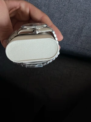 Silverfärgad klocka med länkarmband - Stilren klocka i silver med metallänk och mörk urtavla. Klockan har markerade timindex och räfflad bezel som ger en exklusiv känsla. Perfekt accessoar för dig som gillar klassisk och tidlös design.