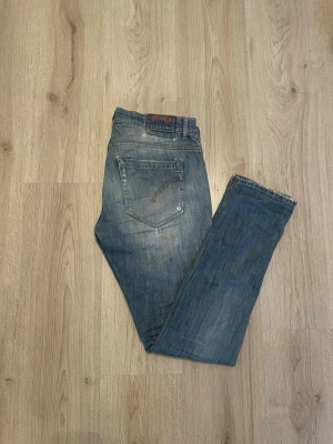 Dondup George - Ett par blå slim fit jeans med slitningar och ljusa tvättade partier. Jeansen har klassisk femficksdesign och normal midja. Perfekta för en avslappnad och trendig look. Skriv privat för mer info!