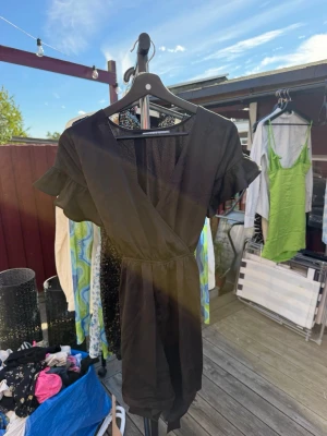 Svart omlottklänning NA-KD🖤 - Kort svart omlottklänning från NA-KD med volangdetaljer på ärmarna och markerad midja. Klänningen har en v-ringad hals och korta ärmar, perfekt för en trendig och enkel stil.