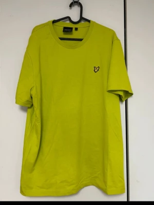 Lyle & Scott man tröja  - Snygg gul t-shirt med rund hals och korta ärmar. På bröstet sitter en liten broderad logga i form av en gul och svart fågel. Perfekt för dig som vill sticka ut med färg i garderoben.