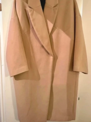 Stradivarius Beige Long Coat - Elegant and effortlessly chic long coat from Stradivarius in a beautiful timeless beige shade.  • Minimalistic design with clean, sophisticated lines • Oversized model for a relaxed and stylish silhouette • Beautiful neutral beige colour — easy to pair with any outfit • Size S — comfortably fits M, or creates an oversized look on S • Worn only a couple of times • Excellent condition — looks like new  A timeless wardrobe staple that instantly elevates any outfit. Perfect for layering over dresses