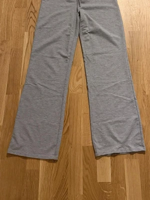 Grå mjukisbyxor från 157 - Mysiga grå mjukisbyxor från 157 med raka ben och resår i midjan. Perfekta för chill dagar hemma eller när du vill ha det extra bekvämt. Tillverkade i mjukt material som känns skönt mot huden. Inte så tjocka och möjligtvis lite tajt passform. Men väldigt mjuka och sköna. Lågmidjade.                                                                          Katt finns i hemmet!!