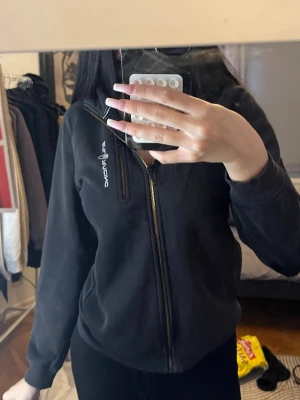 Svart hoodie från Sail Racing