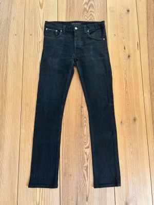 Svarta Nudie Jeans Selvedge - Ett par svarta Nudie Jeans Selvedge, Grim Tim W31 L32. Tror dock att de passar mindre, så kolla mått på sista bilderna!                                       Tveka inte på att höra av dig vid minsta fundering!⭐️