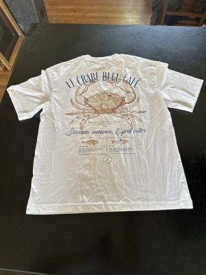 T-shirt  - Vit t shirt med motiv på ryggen aldrig använd då jag gillade inte hur den satt då den är relaxed fit storlek S