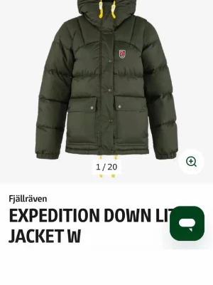 Grön dunjacka Fjällräven Expedition (intressekoll) - Mörkgrön dunjacka från Fjällräven med huva och gula detaljer på snören. Jackan har två stora fickor med lock framtill, tryckknappar och en liten Fjällräven-logga på bröstet. Perfekt för kalla vinterdagar tack vare det tjocka dunfodret.