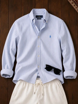 Blårandig skjorta från Ralph Lauren - Säljer en klassisk blårandig skjorta från Ralph Lauren i modellen Knit Oxford. Skjortan har button-down krage, broderad logga på bröstet och vita knappar. Perfekt till jeans eller chinos för en clean och stilren look.
