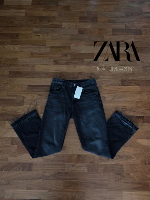 Svarta ZARA Jeans - Flared Fit - ZARA Jeans Flared Fit – Storlek 40 – Helt nya  Stilrena Zara jeans i trendig flared fit-modell med snygg grå tvätt. Smal passform upptill med utsvängda ben som ger en modern och elegant look. Perfekta för både vardag och mer uppklädda outfits. Jeansen är helt nya. Prisslapp avklippt  ✅ Märke: Zara ✅ Modell: Flared Fit ✅ Storlek: 40 ✅ Färg: Svart ✅ Skick: Nytt skick  📦 Snabb leverans – skickas samma dag (om ej hindr.) 📩 Kontakta vid frågor.